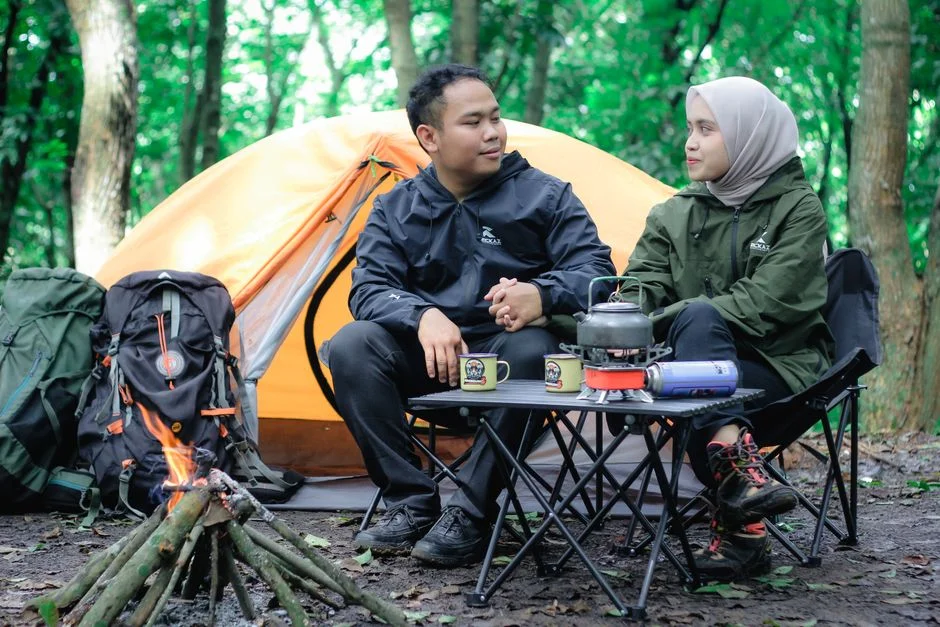 Zwei Camper besprechen bei Kaffee und Kocher die Ausstattung ihres Ausbaus