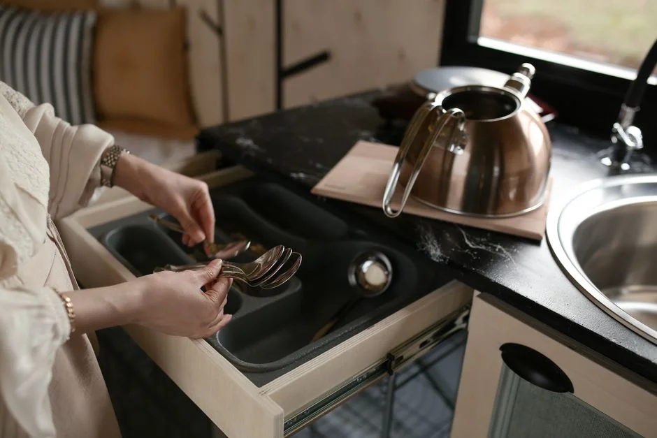 Besteckschublade mit sauberer Führung neben Arbeitsplatte und Spüle im Camper-Innenausbau