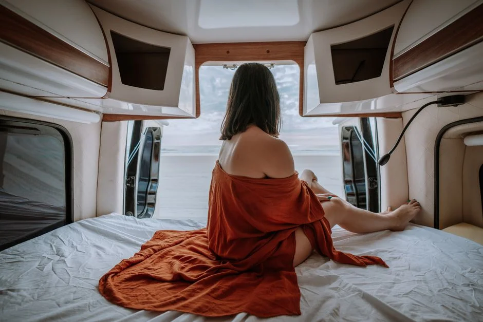 Gemütlicher Camper-Innenraum mit Bett und Decke bei kühler Witterung