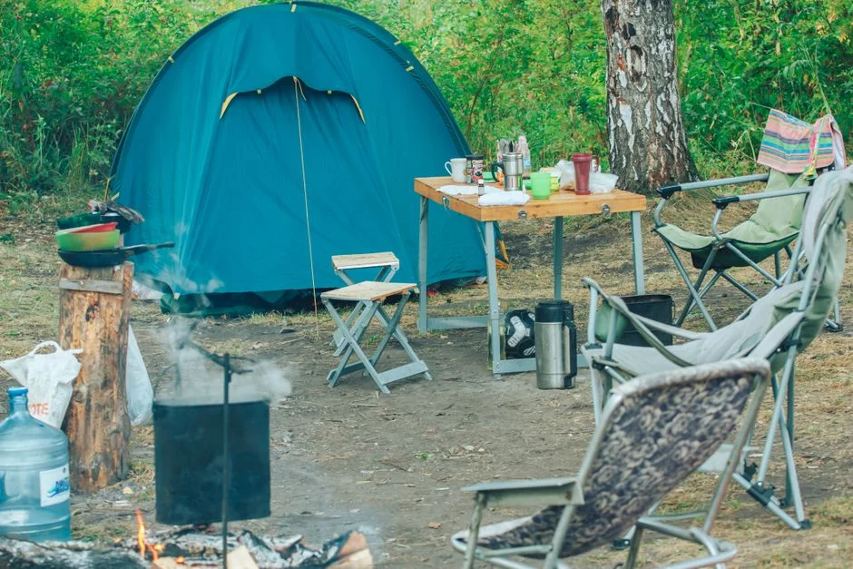 Campingplatz mit Zelt und Campingstühlen als Sinnbild für den Stellplatz-Alltag im Van-/Camper-Lifestyle