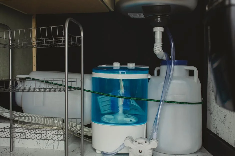 Wasserbehälter und Schläuche in einem Stauraum