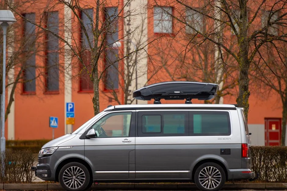 VW Bus Campervan mit geöffneter Heckklappe in Campingumgebung